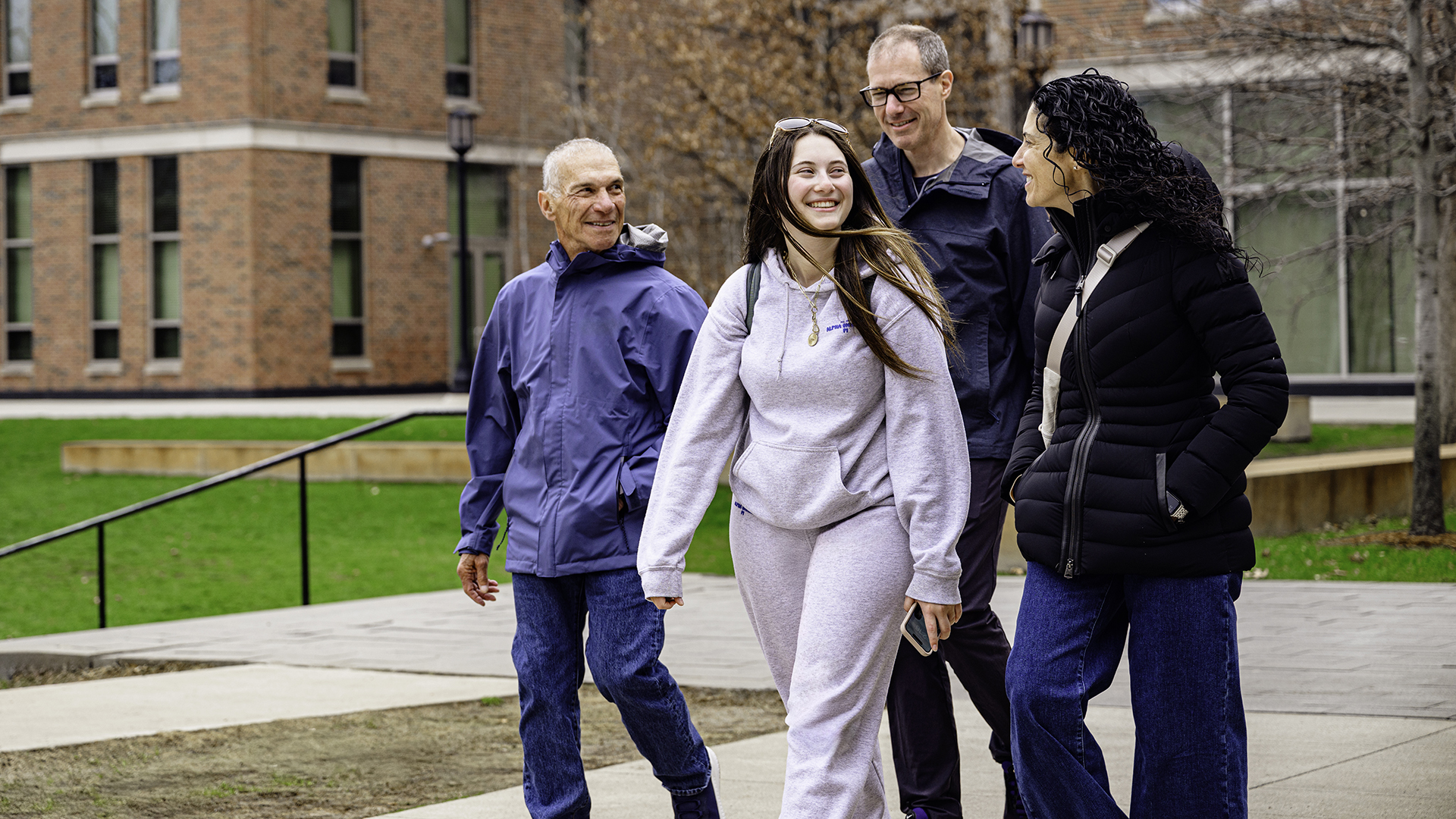 A family walks together with their student on campus.
