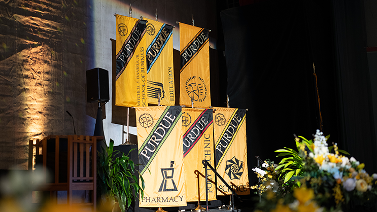 Purdue college banners on stage during commencement