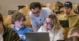 An instructor answers questions from individual students in class.