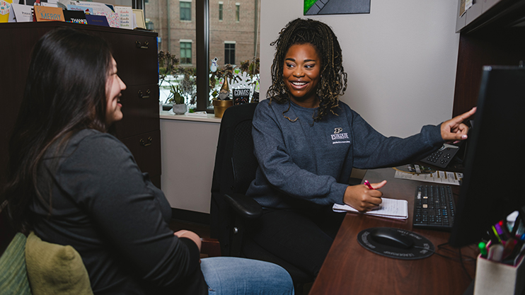 An advisor meets with a student in her office