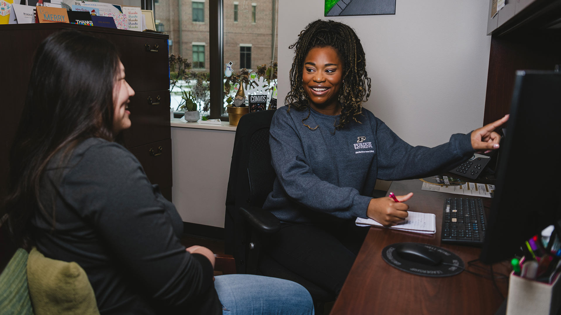 An advisor meets with a student in her office