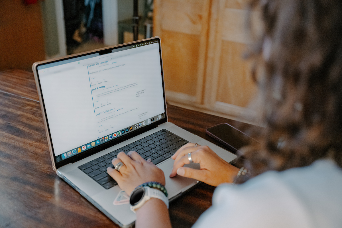 shot of women from behind typing on her computer