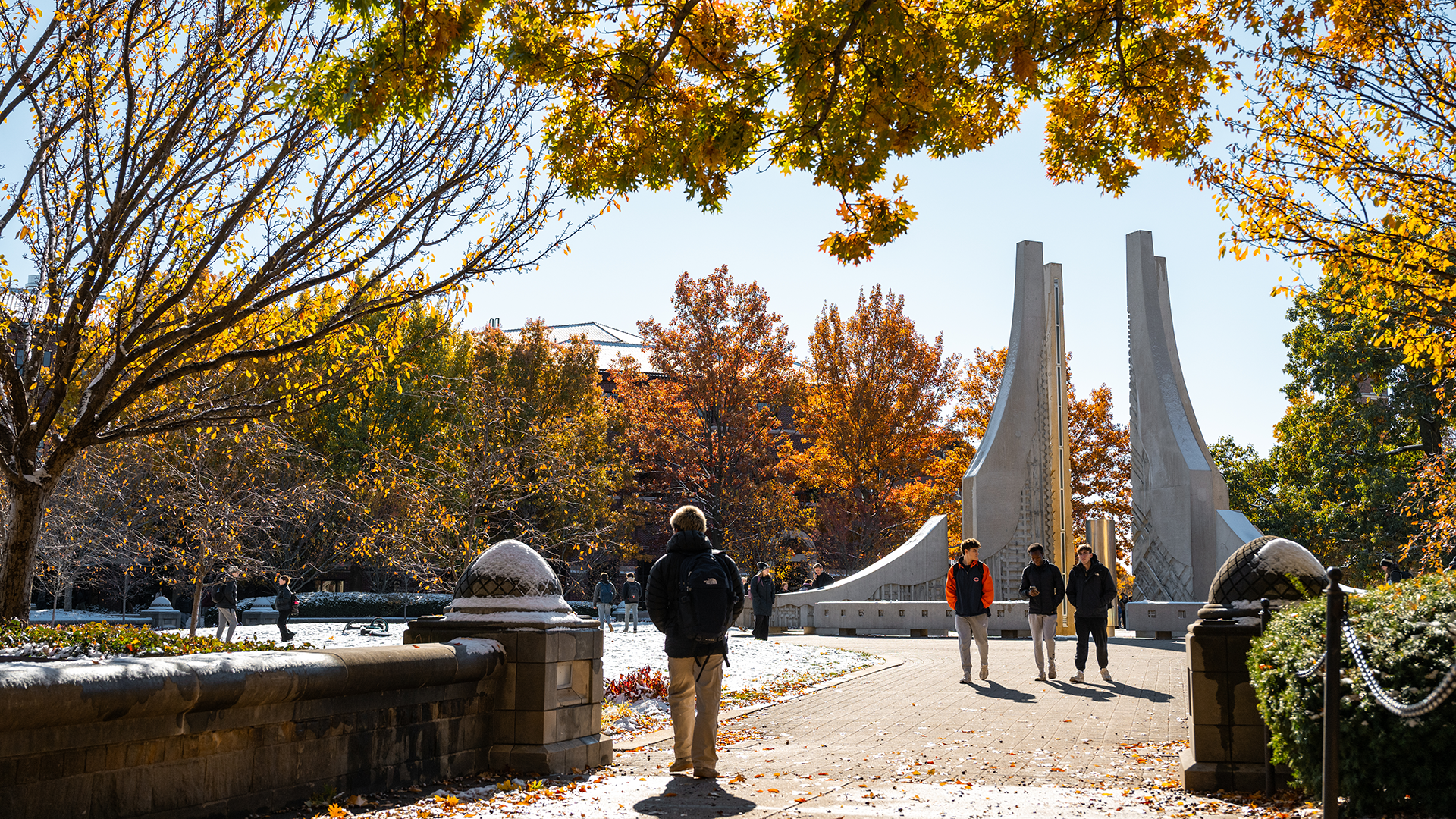 Students walking on campus near the Engineering fountain in the fall