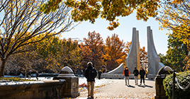 Students walking on campus near the Engineering fountain in the fall