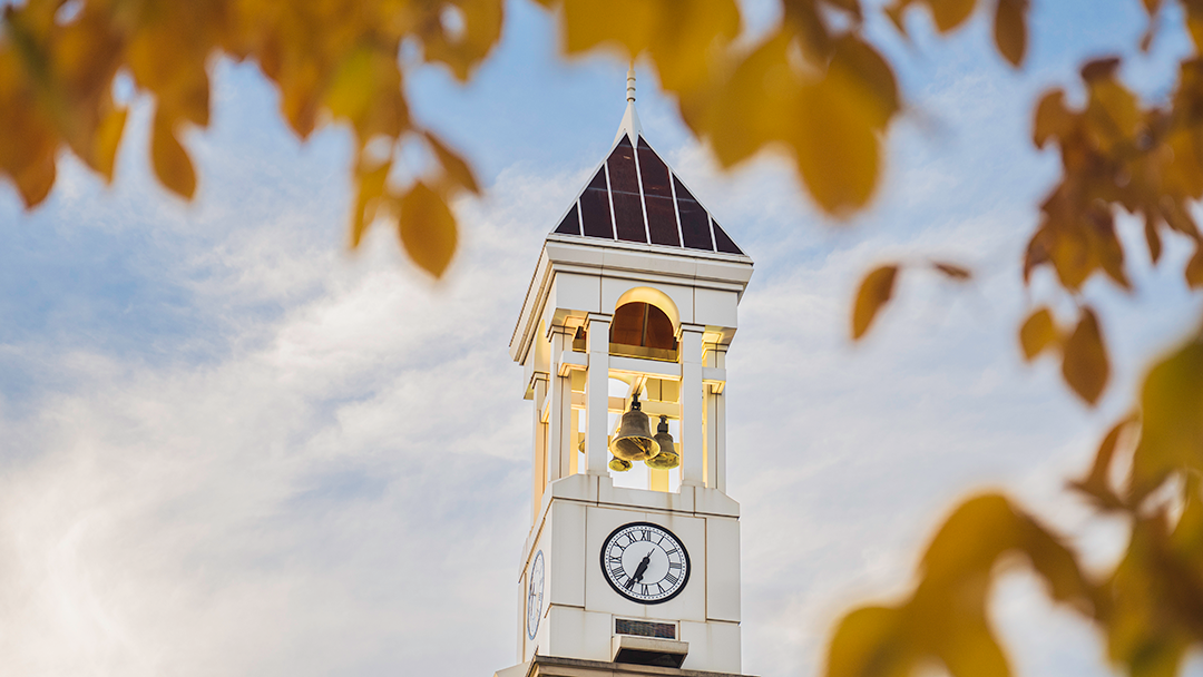 View of Purdue clock tower with fall leaves in the distance