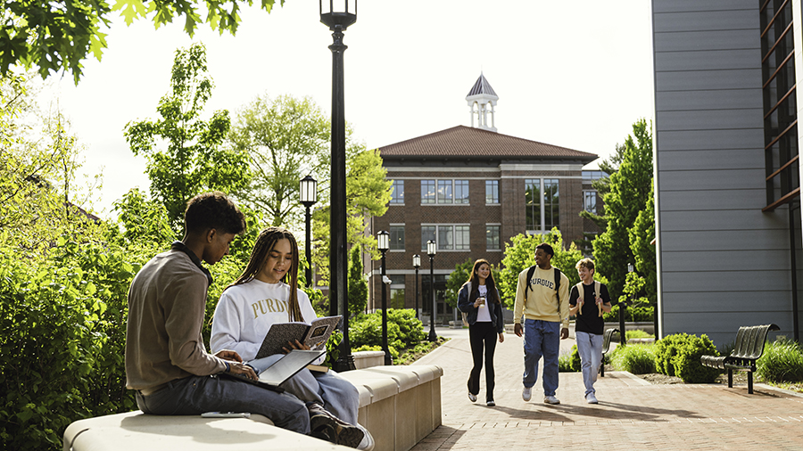 Students sit together outside of academic buildings