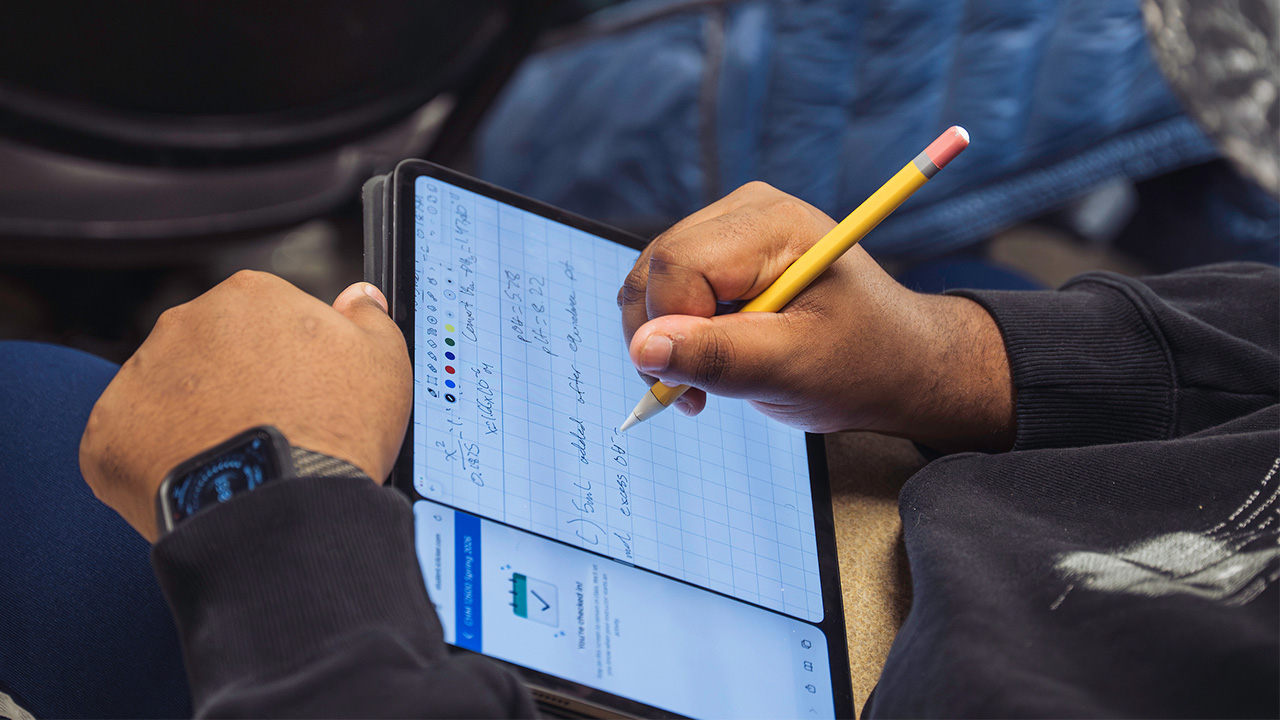 Student using stylus to take notes on a tablet