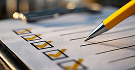 Pen marking a checklist on paper