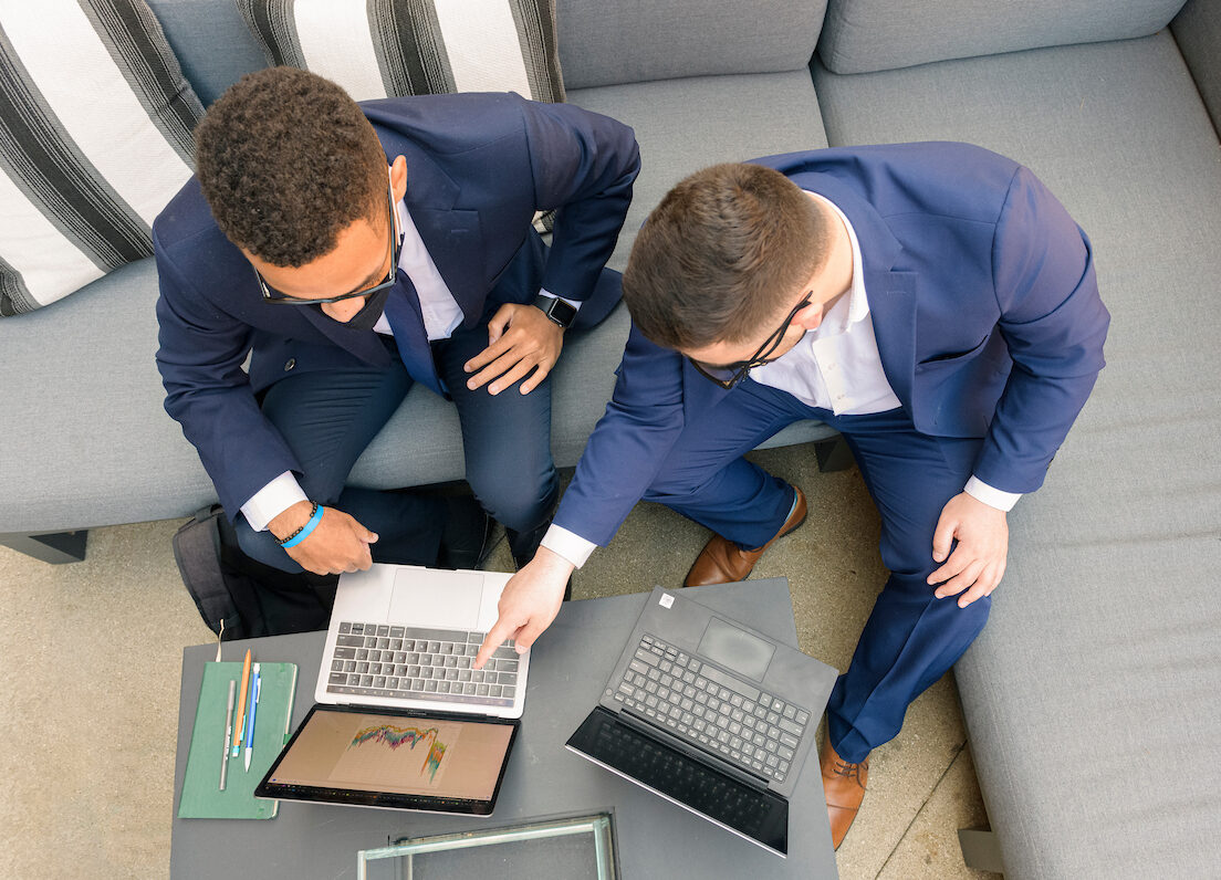image of two males looking at the computer together, pointing at the screen from above