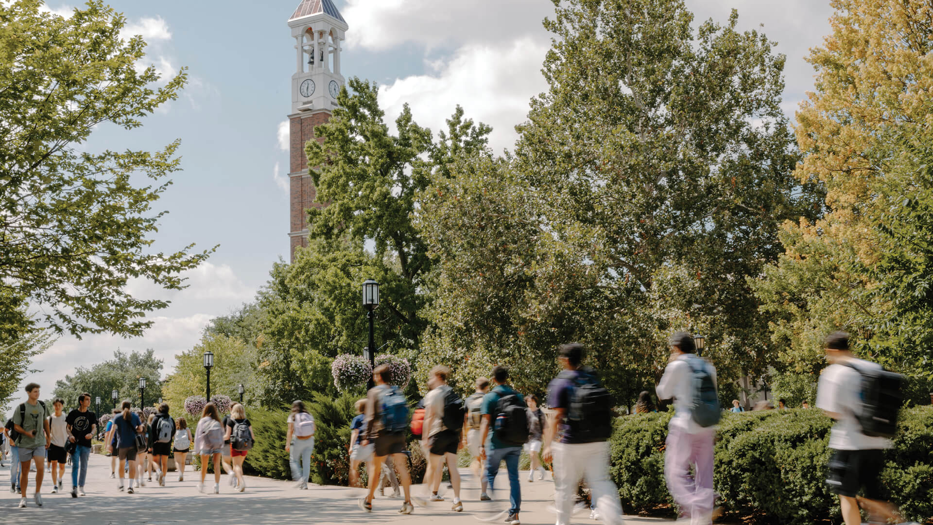 Students walk past the Bell Tower on a sunny day