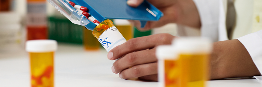 Pills being sorted into a pill bottle.