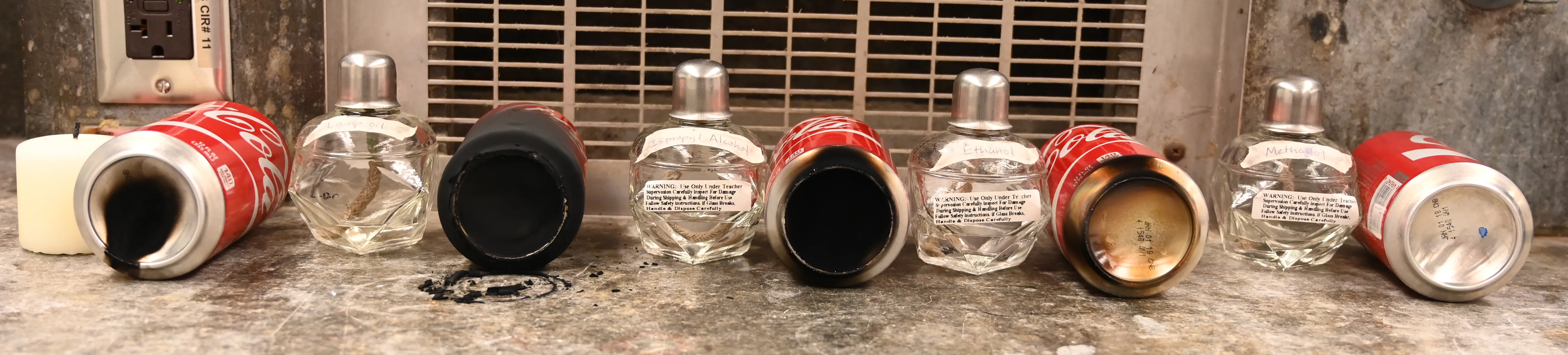 Soot from different fuel sources accumulated on metal cans.