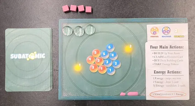 Photo 2. Each player will begin with a Player Mat, 4 Goal Marker cubes, 3 glass Particle Markers, and a starting deck of cards.