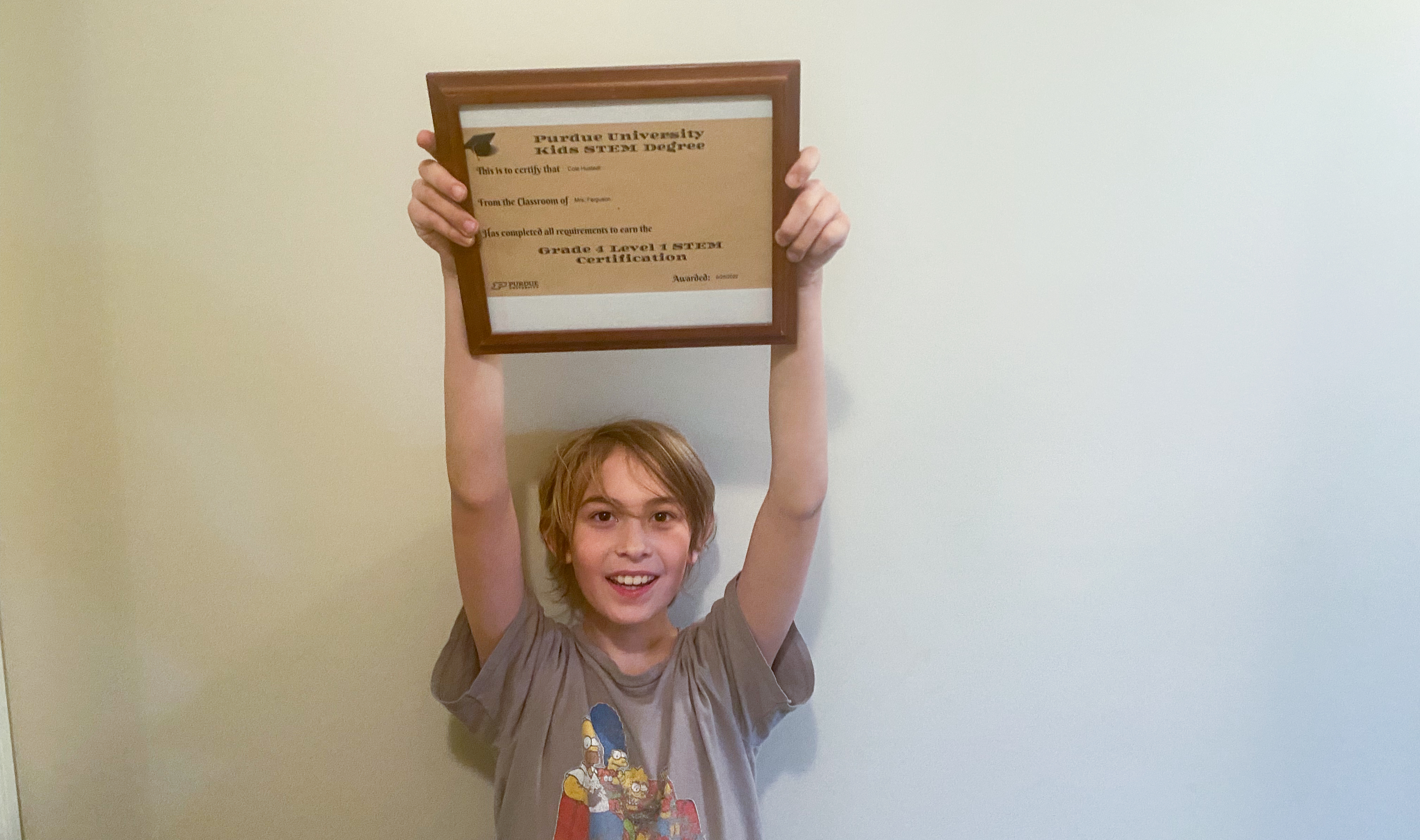 Cole Hustedt holds up his certificate from Purdue College of Science