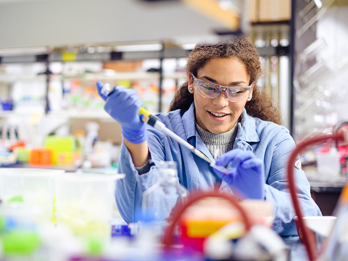 Student in a lab coat conducting research.