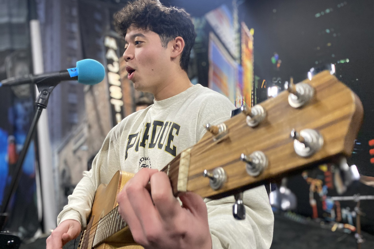 Student playing acoustic guitar and vocals in new JamSpace