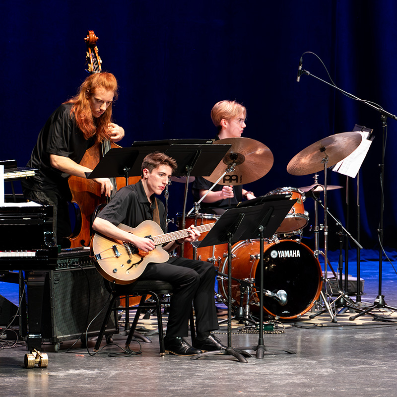 A jazz trio performs on stage at the Purdue Jazz Festival.