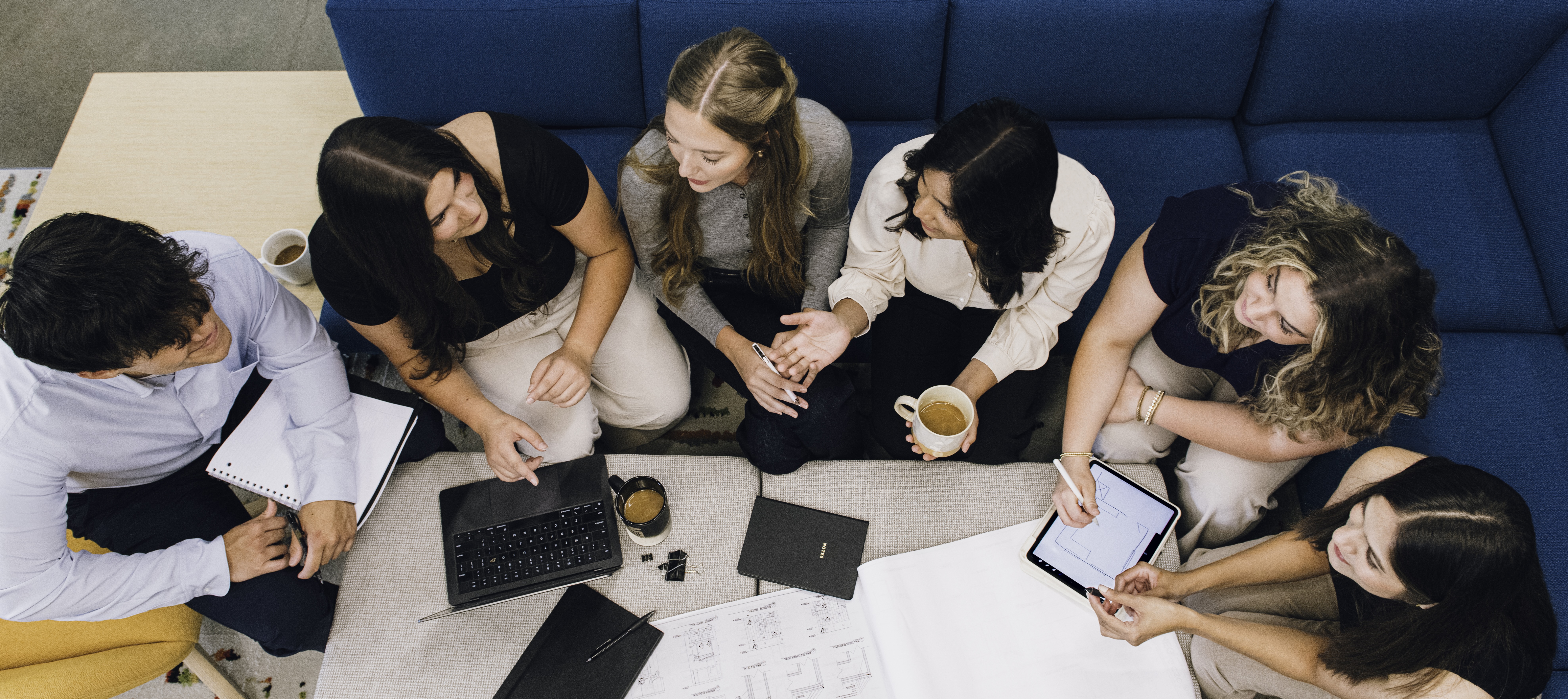multiple students working around a table collaborative