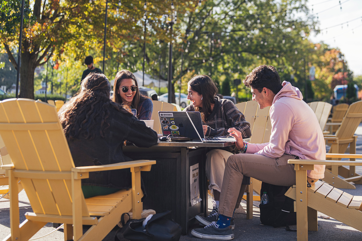 Image showing students gathered around a table outside of Krach Leadership center playing games