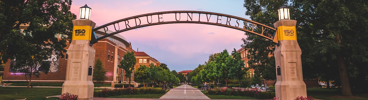 Decorative banner image of Purdue University gate surrounded by trees and flowers