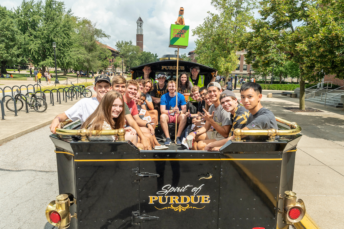 pictured: students ride on the back of the boilermaker special train during boiler gold rush