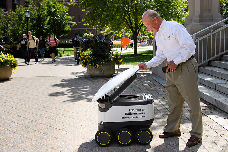 President Daniels taking food from robot