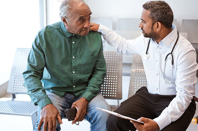 Older man taking with doctor