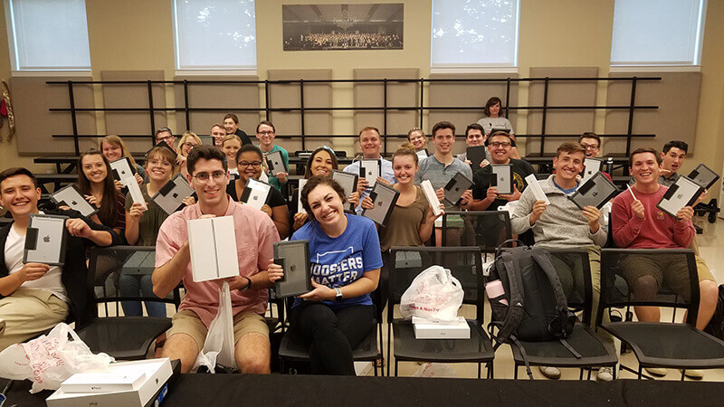 Student in PMO holding iPads