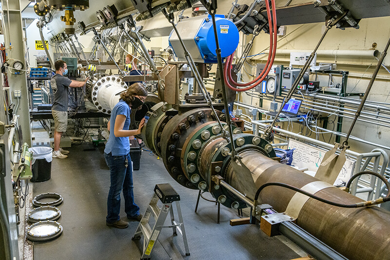 Two students working on the Boeing/AFOSR Mach 6 Quiet Wind Tunnel at Purdue University