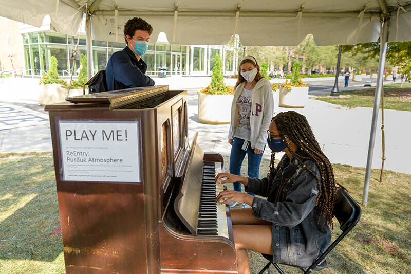 student playing piano under tent