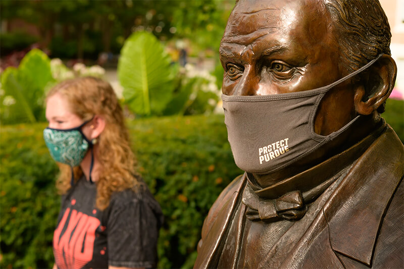 student, John Purdue statue in masks