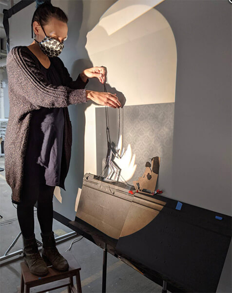 Manual Cinema member, puppet and shadow