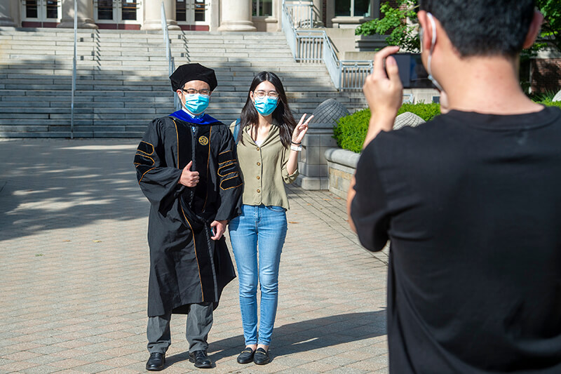 Purdue graduation taking photo in front of Hovde Hall