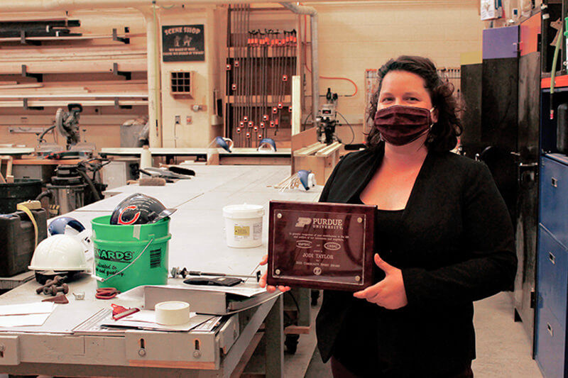 Jodi Taylor with plaque at Purdue Theatre’s Scene Shop