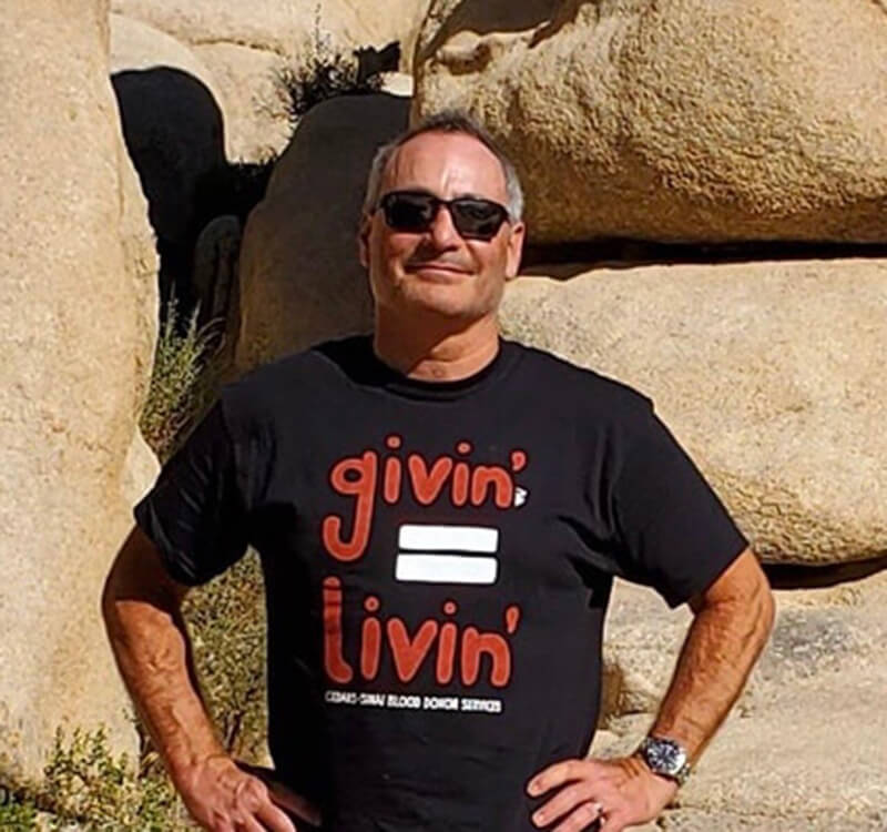 Engel, outdoors in front of large rocks