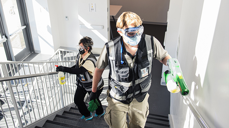 disinfectiing operations team members in stairwell