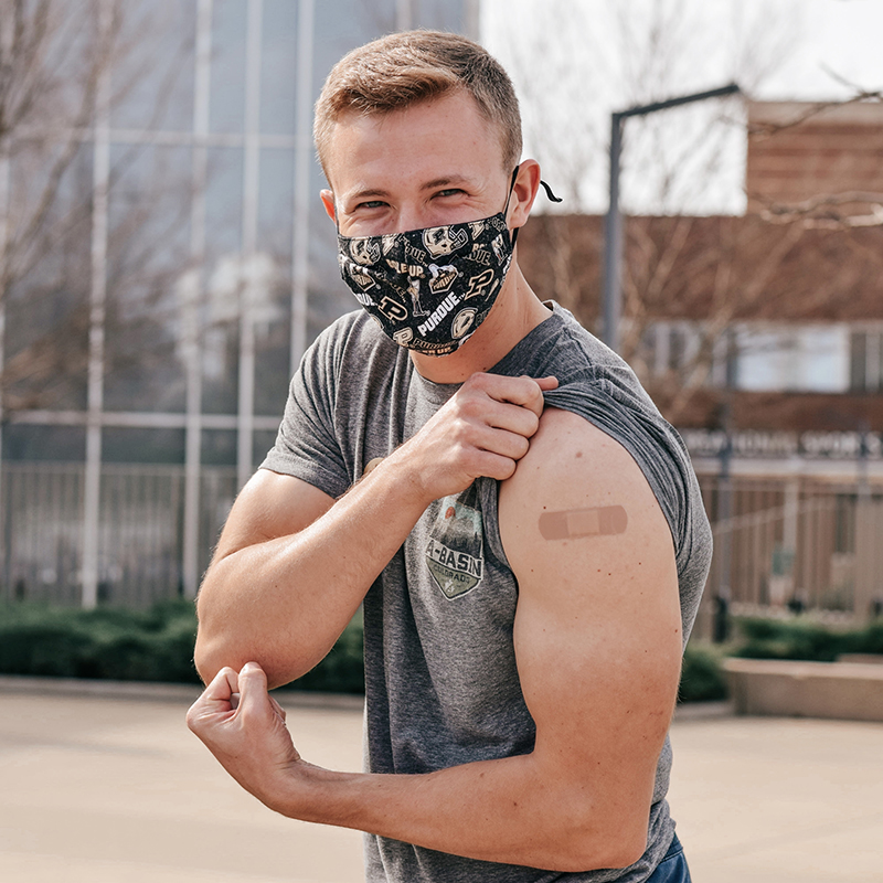 vaccinated student flexing with bandage on arm