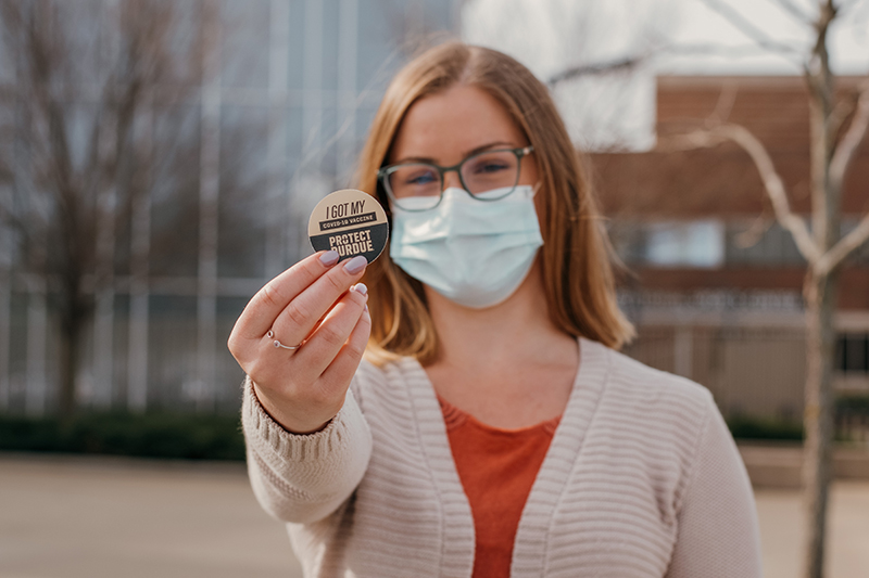 Student holding vaccine sticker