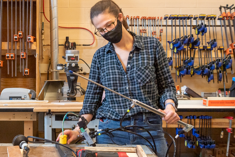 student using tools in work area