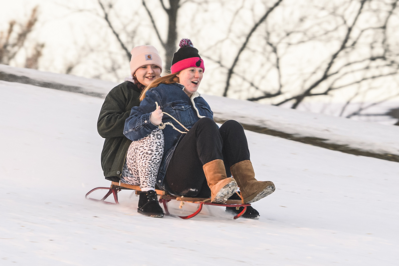 Students sledding at Slayter