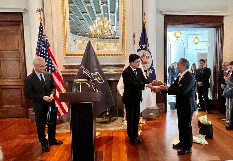 President Chiang presents Purdue Club of Japan president Makoto “Mac” Kaneuji with an autographed Boilermaker football