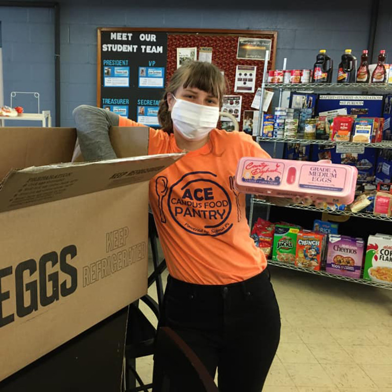 Ace Food Pantry worker holder eggs