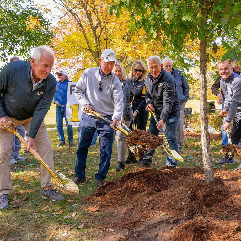 President Mitch Daniels joining others in planting a tree in the Friendship Grove in Pickett Park.