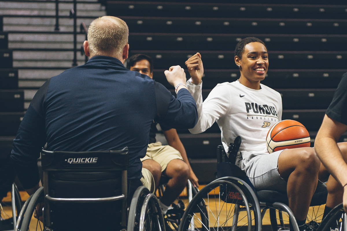 A Purdue basketball player giving someone a fist bump.
