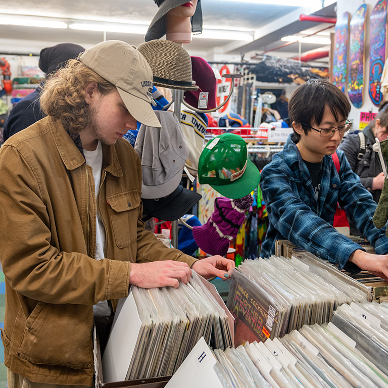 Students browsing through crates full of vinyl records.