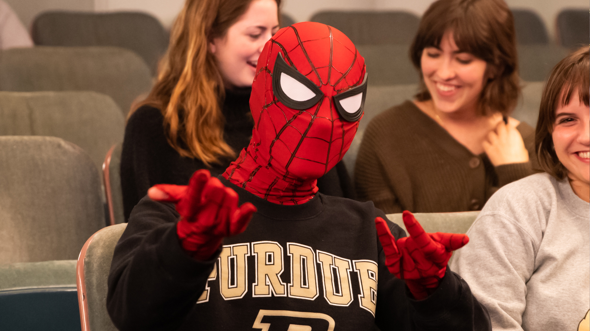 Student in Spiderman costume attending Spiderman performance by Purdue Convocations. 