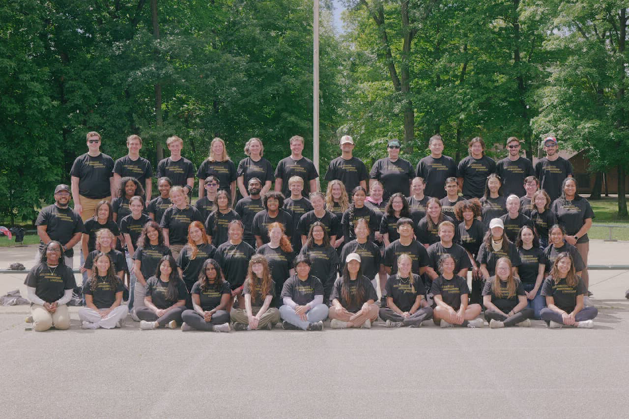 A large group of students in matching shirts pose for a group photo