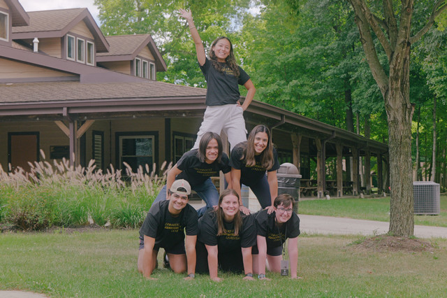Students with matching shirts form a human pyramid 