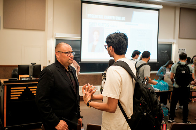 A workshop presenter speaks privately with a student who attended.