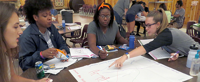 Students at a table discussing a diagram during a workshop
